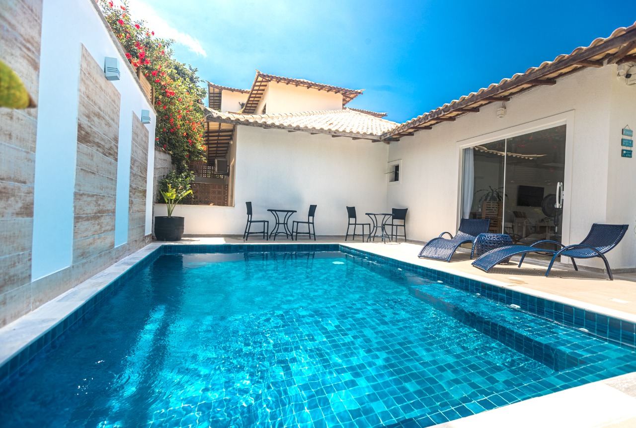 Piscina azul cercada por espreguiçadeiras